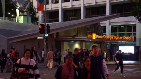 Pedestrians-crossing-the-road-on-Albert-and-Adelaide-street-in-Brisbane-city,-between-King-George-Square-busway-station-and-Queen-Street-Mall,-bus-interchange,-static-shot-at-dusk