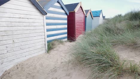 Parte-Trasera-De-Coloridas-Cabañas-De-Playa-A-Lo-Largo-De-Las-Dunas-De-Arena,-Southwold