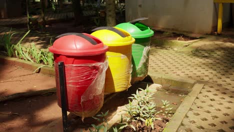 Coloridas-Papeleras-De-Reciclaje-En-Un-Parque-Del-Sudeste-Asiático-En-Un-Día-Soleado