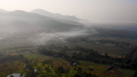 Vista-Aérea-De-Una-Suave-Niebla-Sobre-Campos-Agrícolas-En-Las-Montañas-De-Tailandia