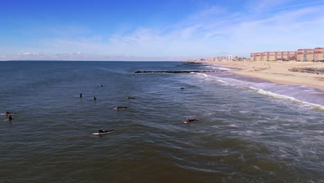 Una-Vista-Aérea-De-Surfistas-Disfrutando-Del-Océano-En-Un-Día-Soleado