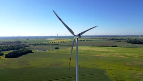 Drone-view-of-spinning-wind-turbine-blades,-renewable-energy-source