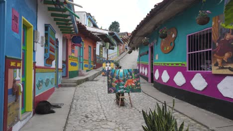 Walking-pov-through-a-decorated-street-in-Guatapé,-souvenir-shops-in-Pedestrian-street