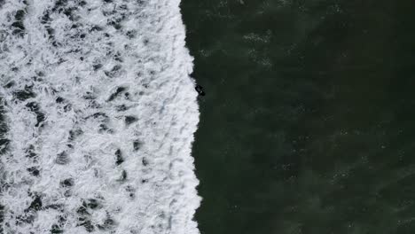 Aerial-view-following-a-man-on-an-electric-hydrofoil-personal-water-craft-surfboard-riding-in-the-ocean-at-sunrise,-the-future-of-electric-water-transportation-and-vehicles