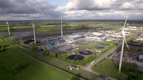 Steady-aerial-of-clean-energy-wind-turbines-solar-panels-and-water-purifying-facility-hub-in-agrarian-seen-from-above