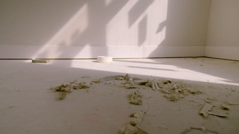 Slow-Pan-of-Plaster-and-Tape-in-Light-on-Floor-of-New-Build