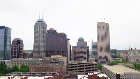 Downtown-district-Indianapolis-skyline-aerial-view-flying-towards-city-skyscrapers,-Indiana