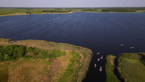 Boats-sailing-toward-lake-from-small-township-of-Giethoorn,-aerial-view