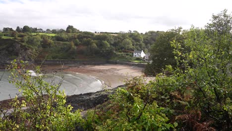 Strand-Und-Gebäude-Am-Wasser-Auf-Dinas-Island,-Wales,-Großbritannien-An-Einem-Sonnigen-Frühlingstag,-Aussichtspunkt-Pov