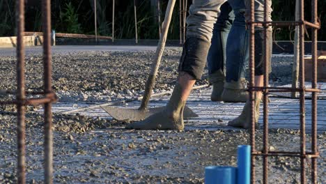 Detail-of-worker-adjusting-concrete-on-floor-of-new-residence