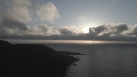 Joao-bom-trail-overlooking-mosteiros-village-at-sunrise-with-dramatic-clouds,-aerial-view