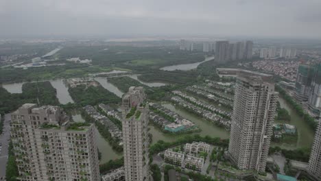 Aerial-of-Hanoi's-skyline,-where-high-rise-structures-are-crowned-with-lush-greenery,-echoing-a-contemporary-urban-oasis