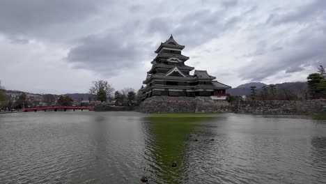 Alte-Japanische-Burg-Vor-Dem-Wasser,-Die-Sich-Im-Wasser-Spiegelt