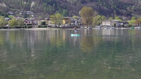 A-man-using-a-paddle-board-on-lake-Caldonazzo-on-a-nice-and-sunny-day-in-early-spring