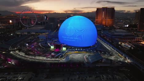 AERIAL:-Illuminated-Sphere-entertainment-arena,-vibrant-dusk-in-Las-Vegas,-USA
