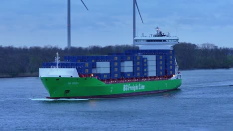 Container-vessel-BG-Green-sailing-near-Barendrecht,-blue-sunset-sky