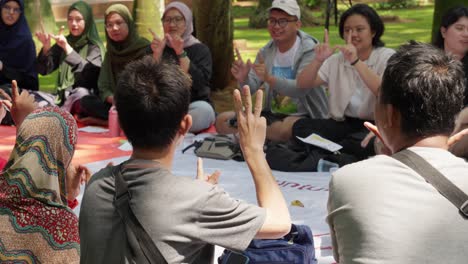 Un-Grupo-Aprende-Lengua-De-Signos-Para-Sordos-En-El-Parque-Taman-Kota-1,-BSD,-Indonesia.