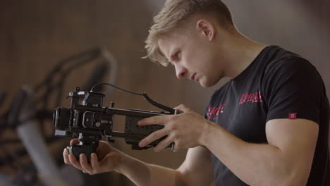 Blond-guy-with-camera-makes-content-of-another-athlete-in-the-gym,-profile-view