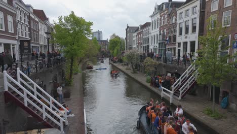 People-celebrating-Kings-Day-on-boats-in-a-canal-in-Utrecht,-Netherlands