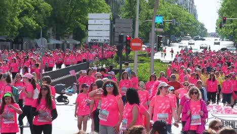 Beim-Frauenrennen-In-Madrid,-Spanien,-Trinken-Teilnehmerinnen-In-Rosa-Shirts-Flüssigkeit-Und-Machen-Auf-Metastasierten-Brustkrebs-Aufmerksam