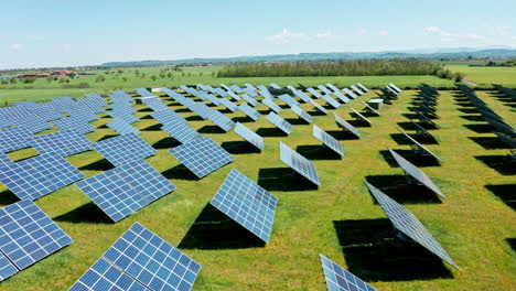 Solar-panels-arranged-in-rows-on-a-green-field-on-a-sunny-day