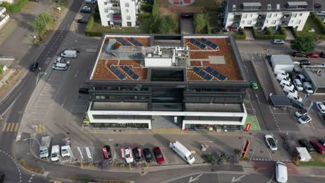 Antena-De-Un-Pequeño-Edificio-De-Oficinas-Con-Paneles-Solares-Fotovoltaicos-En-La-Azotea.