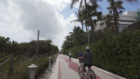 Strandpromenade-Von-Miami-Mit-Radfahrer-Unter-Palmen-Und-Teilweise-Bewölktem-Himmel