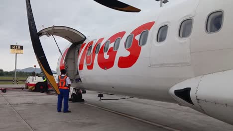 Un-Oficial-Comprueba-Los-Preparativos-De-Vuelo-De-Un-Avión-Wings-Air-Atr-72-En-El-Aeropuerto-Internacional-Sultan-Hasanuddin-De-Makassar,-Indonesia