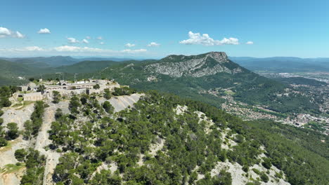 Fort-de-la-croix-faron-on-a-sunny-day-with-expansive-mountain-and-valley-scenery,-aerial-view