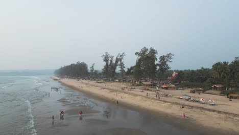 Drone-Fly-Above-People-and-Palm-Trees-on-Sandy-Beach