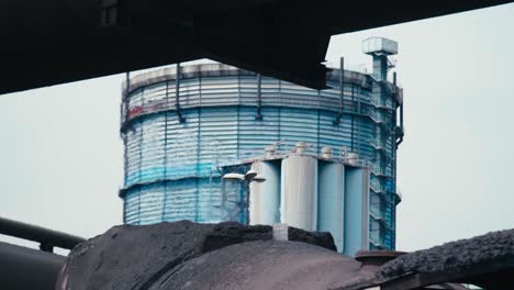 Train-with-molten-steel-drives-in-the-foreground,-heat-distorting-air,-industrial-background