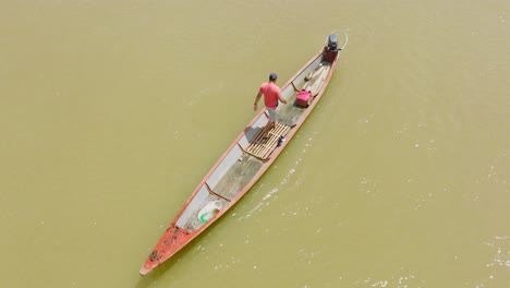 Hombre-En-Un-Barco-De-Madera-Navegando-Por-Las-Turbias-Aguas-De-Florencia,-Colombia,-Vista-Aérea