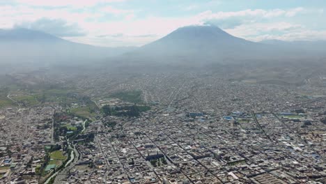 Genießen-Sie-Eine-Atemberaubende-Luftaufnahme-Von-Der-Plaza-De-Armas-In-Arequipa,-Mit-Einer-Aufregenden-Schwenkbewegung-Von-Links-Nach-Rechts,-Die-Den-Majestätischen,-Nebligen-Vulkan-Und-Die-Gesamte-Stadt-In-Einem-Spektakulären-Panorama-Enthüllt