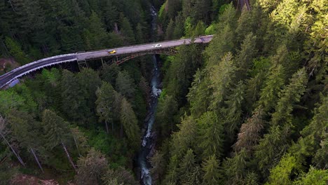 Escénica-Toma-Aérea-Descendente-Sobre-Un-Río-Que-Fluye-En-Un-Bosque-Siempre-Verde-Que-Muestra-Un-Puente-De-Acero-En-Carbonado,-Estado-De-Washington