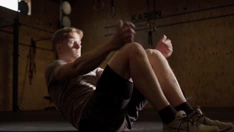 Caucasian-man-does-sit-up-workout-routine-in-gym