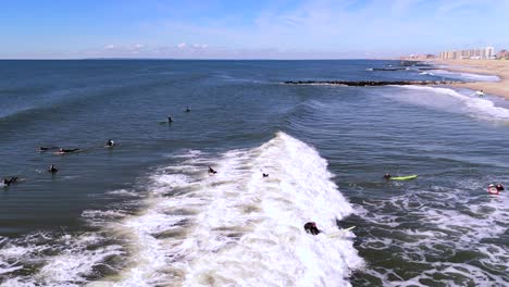 An-aerial-view-of-surfers-enjoying-the-ocean-on-a-sunny-day