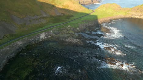 Wide-aerial-shot-of-the-shoreline-of-The-Giant's-Causeway,-County-Antrim-in-Northern-Ireland-on-a-sunny-morning