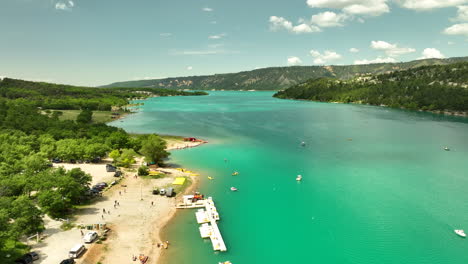Gorges-du-verdon-lake-with-turquoise-water-and-surrounding-green-hills,-aerial-view