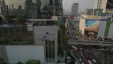 Aerial-orbit-around-reflective-Bangkok-CBD-skyscraper-with-rooftop-pool