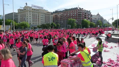 Beim-Frauenrennen-In-Madrid,-Spanien,-Trinken-Teilnehmerinnen-In-Rosa-Shirts-Flüssigkeit-Und-Machen-Auf-Metastasierten-Brustkrebs-Aufmerksam