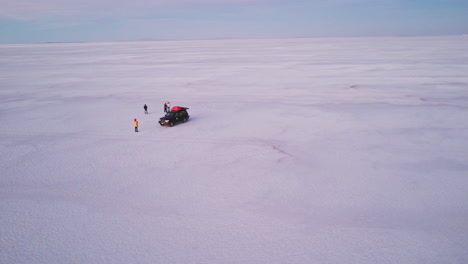 Un-Grupo-De-Amigos-Juegan-Juntos-En-Un-Paisaje-Blanco,-Limpio-Y-Seco-De-Salinas,-Bolivia