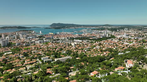 Toulon-cityscape-with-mediterranean-sea-and-distant-mountains-on-a-sunny-day,-aerial-view
