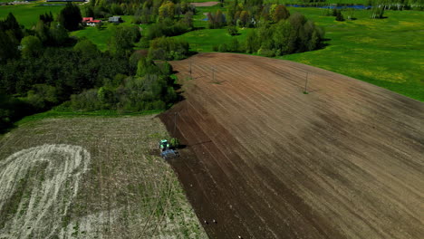 Panoramic-Aerial-View-Of-Tractor-Ploughing-A-Fertile-Agricultural-Field