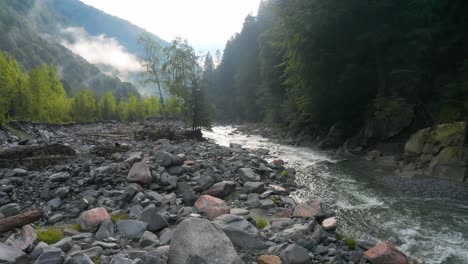 Stunning-Aerial-Shot-Following-River-and-Forest-in-Mountains-Near-Spruga-Locarno,-Switzerland-Italy