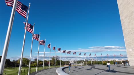 A-lot-of-American-Flags-standing-at-Washington-Monument,-waving-in-the-wind