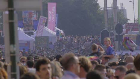 Large-crowd-at-Pride-Village-festival,-colorful-unicorn-balloon-in-the-background