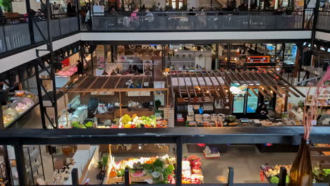 High-angle-shot-of-people-shopping-for-fruits-and-vegetables-at-a-supermarket-with-a-cafeteria-on-the-top-floor