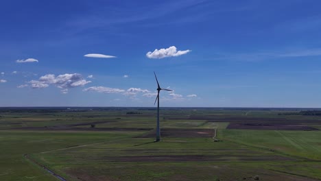 Una-Solitaria-Turbina-Eólica-Se-Alza-En-Un-Vasto-Campo-Verde-Bajo-Un-Cielo-Azul-Brillante