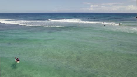 Vista-Aérea-Rodeando-A-La-Gente-En-Aguas-Poco-Profundas-De-Isabela,-Día-Soleado-En-Puerto-Rico