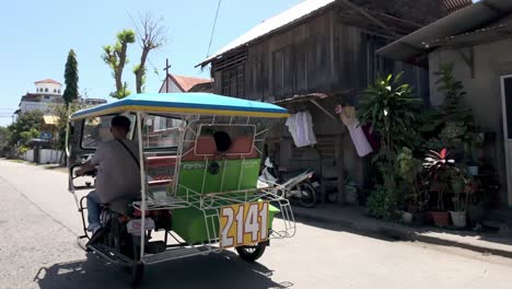 Philippines,-Dumaguete:-The-video-captures-passing-by-a-tuk-tuk-on-a-Dumaguete-road,-viewed-from-inside-our-tuk-tuk